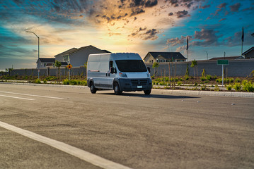 white cargo van driving down road during sunset © Alexandr Ivaschenko