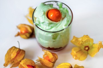 Glass with pistachio cream with physalis fruit.