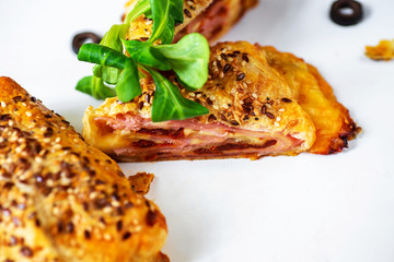 Puff pastry stuffed with ham, cheese, dried tomatoes and olives.