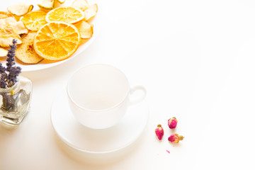 herbal tea ingredients and empty white cup on white background