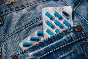 Two packages of blue capsules in the pocket of his pants.Pills for men's health and sexual energy...