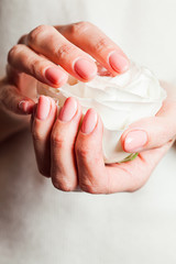 Woman holds in hands fragily pink rose