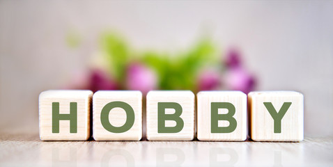Hobby concept on wooden cubes with a bouquet of flowers