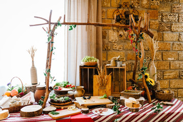 Decorations made of wood and wildflowers served on the festive table setting in rustic style for wedding ceremony. Wooden stage, wall on the restaurant for party.
