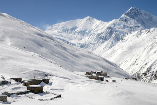Annapurna Circuit trek. Himalayan landscape with guest house, Anapurna III Peak (7 555 m) Gangapurna Peak (7 455 m) on the background. High Churi, Lettar Manang, Nepal.