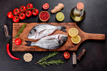Raw dorado fish with spices cooking on cutting board. Fresh fish dorado