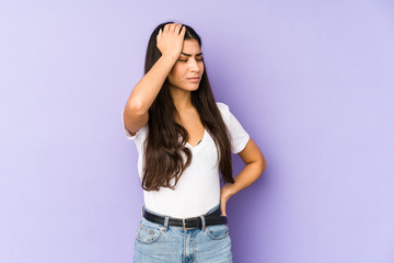 Young indian woman isolated on purple background forgetting something, slapping forehead with palm and closing eyes.