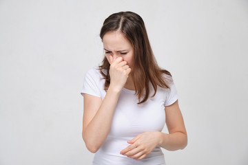 Obraz premium A girl in a white T-shirt has difficulty breathing through her nose. Consequences after plastic surgery.