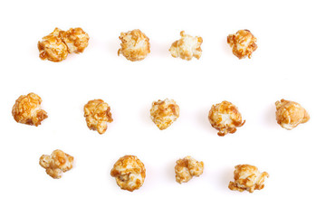 Heap of delicious caramel popcorn, isolated on white background . Scattered popcorn texture background.
