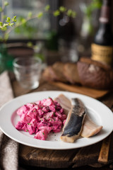Fototapeta na wymiar Homemade Beet and Potato Salad Served with Salted Herring Fillet