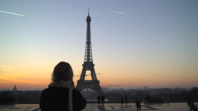 Woman taking photo of Eiffel Tower with phone