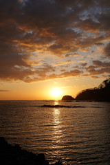 Fototapeta premium Beautiful sunset on the beach of Costa Rica with yellow Skys and an island 