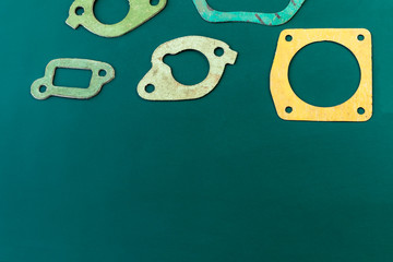 The graphic background is green. Gasket silencer, manifold, thermostat. Close-up. Copy space.