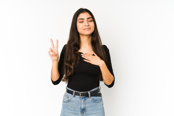 Young indian woman isolated on purple background taking an oath, putting hand on chest.