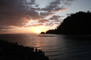 Beautiful sunset on the beach of Costa Rica with yellow Skys and an island 