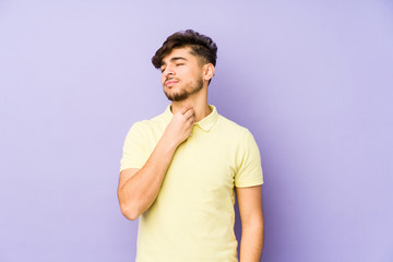 Young arabian man isolated on a purple background suffers pain in throat due a virus or infection.
