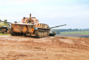 Fototapeta premium Military tanks in mud against white sky