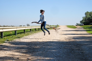 Obraz premium Girl flying above the ground on a broomstick