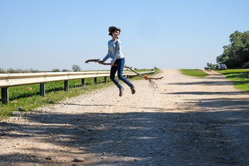 Girl flying above the ground on a broomstick