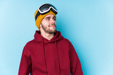 Young caucasian man wearing a ski clothes isolated dreaming of achieving goals and purposes