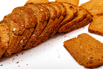 Top view of fresh sliced wholegrain or multi grain bread on dark ructic wooden background, close up.
