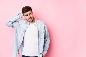 Young caucasian business man posing in a white background isolated touching back of head, thinking and making a choice.< mixto >