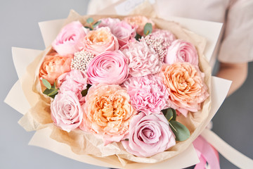 European floral shop. Beautiful bouquet of mixed flowers in womans hands. the work of the florist at a flower shop. Delivery fresh cut flower.
