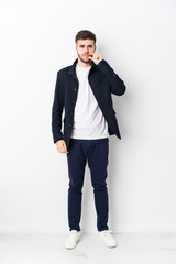 Full body young caucasian man isolated with fingers on lips keeping a secret.