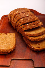 Top view of fresh sliced wholegrain or multi grain bread on dark ructic wooden background, close up.