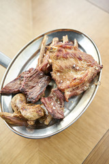 Various grilled meat set heated on coals. Barbecue restaurant menu. Many different food on the table. Dinner party or Banquet