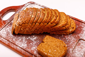 Top view of fresh sliced wholegrain or multi grain bread on dark ructic wooden background, close up.