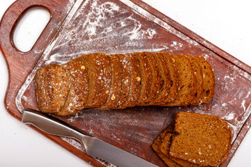 Top view of fresh sliced wholegrain or multi grain bread on dark ructic wooden background, close up.