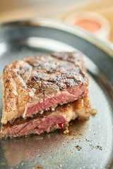 plate Grilled striploin steak. The strip steak, also called a New York strip. Serving on a wooden Board. Barbecue restaurant menu.