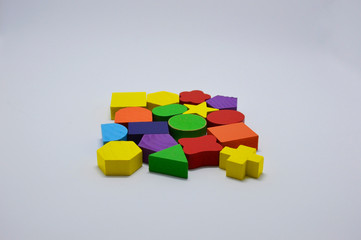 Obraz premium wooden toys on a white background. wooden figures of different shapes and colors. toys for children