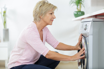 elderly woman next to a washing machine