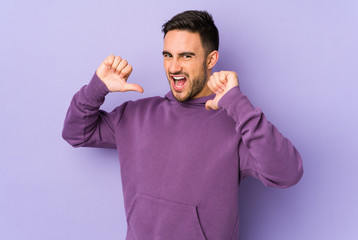 Young caucasian man isolated on purple background feels proud and self confident, example to follow.