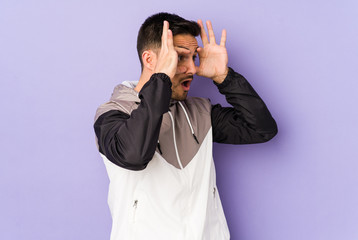 Young caucasian man isolated on purple background keeping eyes opened to find a success opportunity.