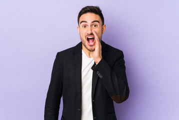 Young caucasian man isolated on purple background is saying a secret hot braking news and looking aside