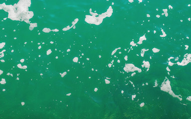 Turquoise sea water with foam. Abstract sea background. Ocean waves close-up.  Soft focus.