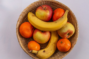 Fruit basket - ripe banana, orange and juicy apples