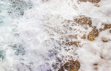Beach texture. Golden sand and sea foam pattern. Beach background with copy space. Abstract sea background. Ocean waves close-up.