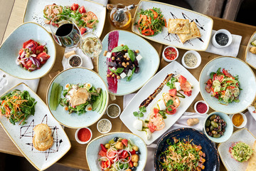 Many different delicious dishes dishes on the table. Various snacks and antipasti on the table. Restaurant menu. Italian cuisine
