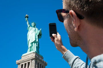 Personal point of view perspective of tourist taking photo of the Statue of Liberty with his mobile phone © PeskyMonkey