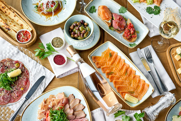 Beef tartar in the restaurant. Variety of dishes on the table. Various snacks and antipasti on the table. Restaurant menu. Italian cuisine