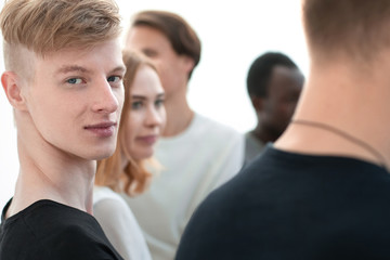 smiling guy sitting in a circle at a group meeting