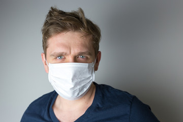 Man with mask to protect him from virus. The concept of the epidemic of the coronavirus. Tired Doctor with medical white mask.