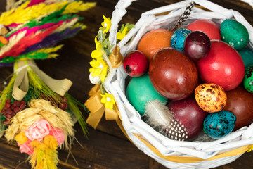 Happy Easter.  Traditionally, colorfully painted eggs in a basket.  Background of old boards, festive decor