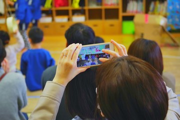 参観日 子供を撮影する人