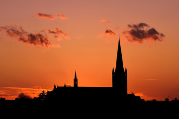 Naklejka premium Church building exterior in silhouette of sunrise or sunset with glowing sunlight