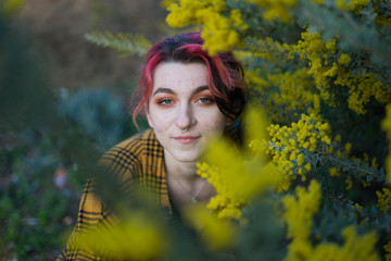 emo woman with red hair and septum piercing smiling at the camera